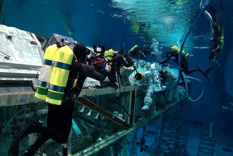 Jonathan filming an astronaut working on the ISS replica with support divers watching. &copy; Jonathan Bird’s Blue World TV
